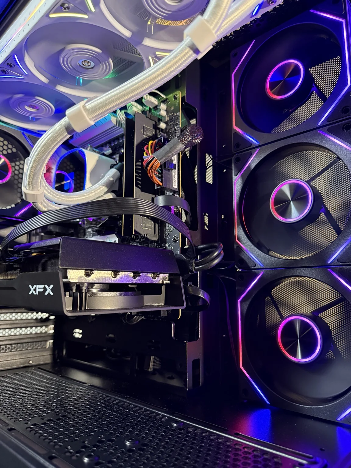 Interior de una PC armada desde cero por RAW TECH, con refrigeración líquida blanca y ventiladores con iluminación